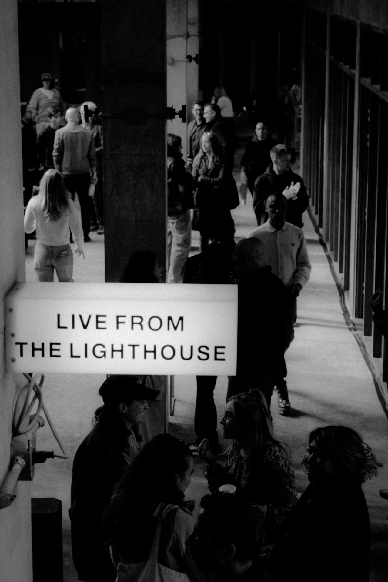 Guests gathering beside the Live from The Lighthouse sign
